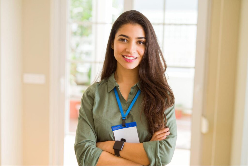 Uma mulher sorrindo com um crachá.